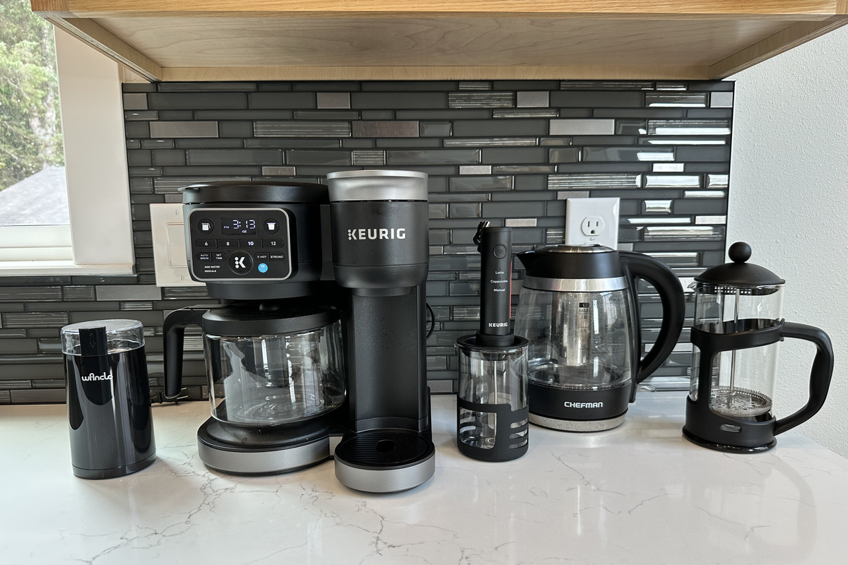 Pick your poison before anyone else is awake — grinder, Keurig, frother, kettle, and French press all lined up so nobody has to wait for the good coffee.