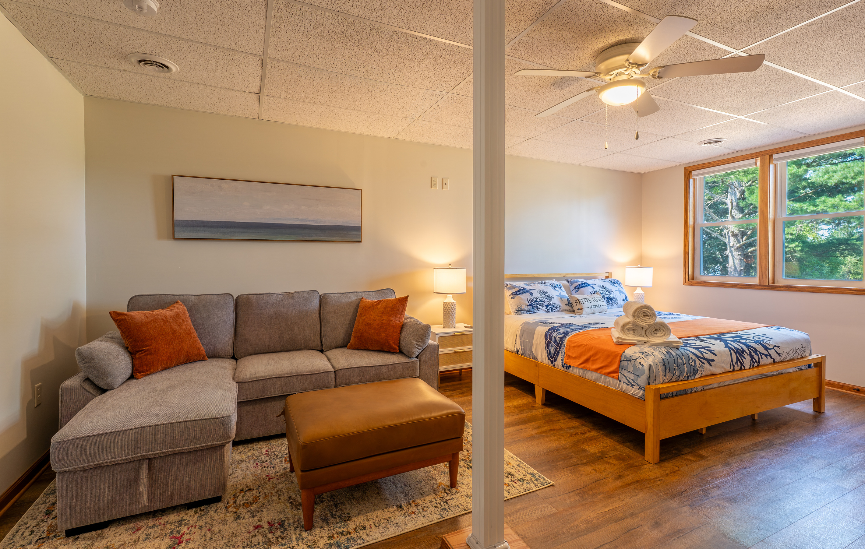The flex room doubles as a 5th bedroom or a private lounge. It features a king bed, a queen sleeper sofa, and a full-size sleeping futon (not pictured), with its own 65" Smart Roku TV and direct access to the lower-level amenities