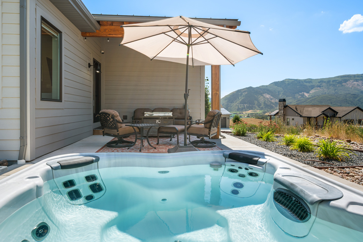 Unwind under the Utah sky in the private hot tub, surrounded by mountain views and a spacious patio designed for outdoor relaxation.