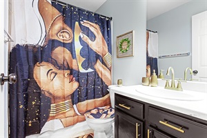 Spa-like bathroom with a modern vanity and a touch of artistic flair. Perfect for unwinding after a long day.