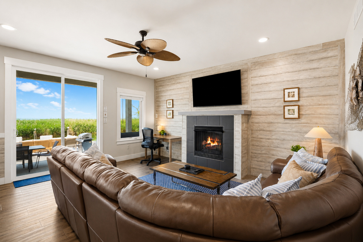 Gather in the spacious first-floor living room featuring a cozy fireplace, dedicated workspace, and stunning views of the backyard, canal, and Lake St. Clair. The perfect place to relax, work remotely, or unwind after a day on the water.