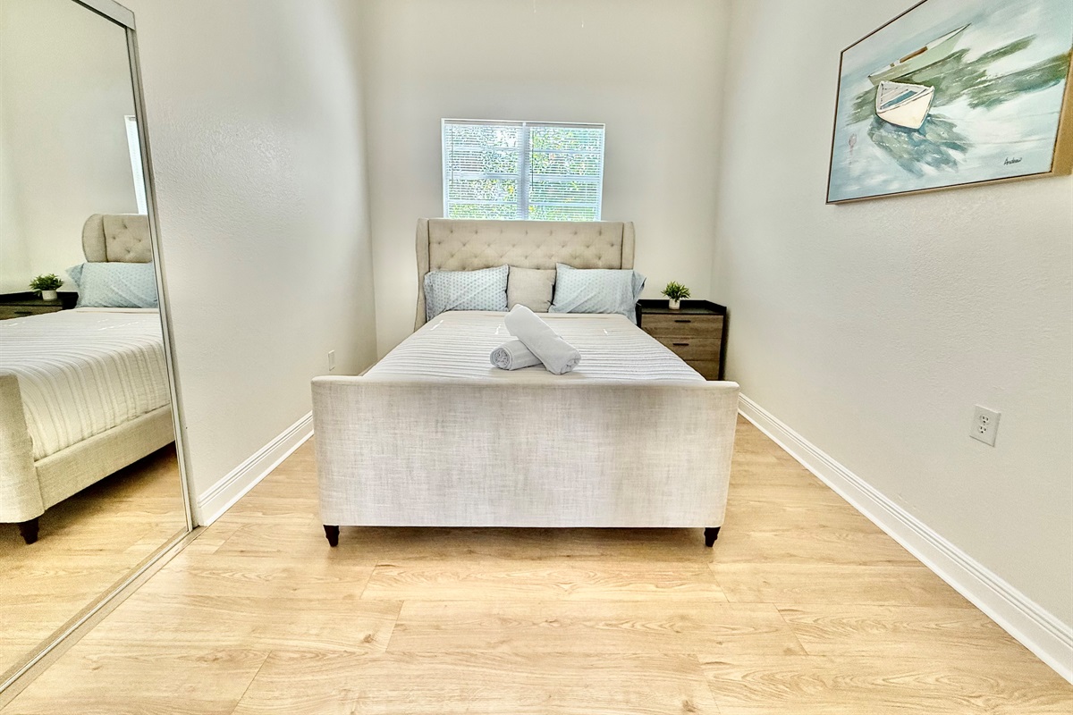 Soft tones, clean lines, and a wingback headboard create a bedroom that feels both upscale and welcoming.