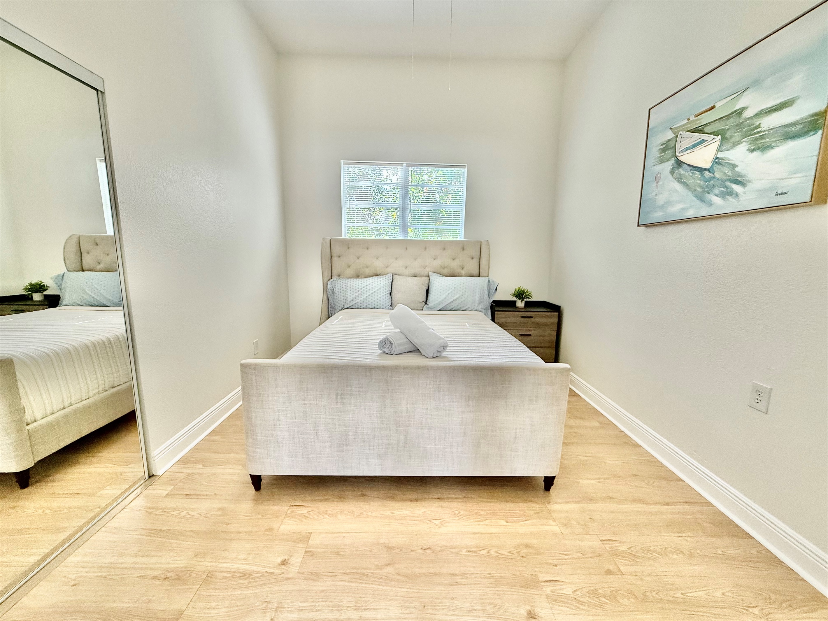Soft tones, clean lines, and a wingback headboard create a bedroom that feels both upscale and welcoming.