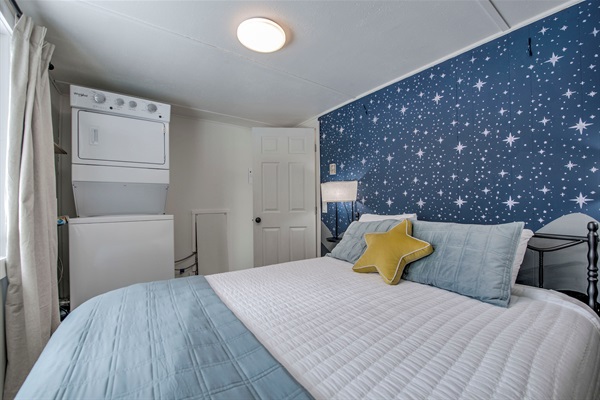 Rest easy in your cozy retreat—starry accent wall, soft linens, and added convenience make this space perfectly yours for a relaxing stay.