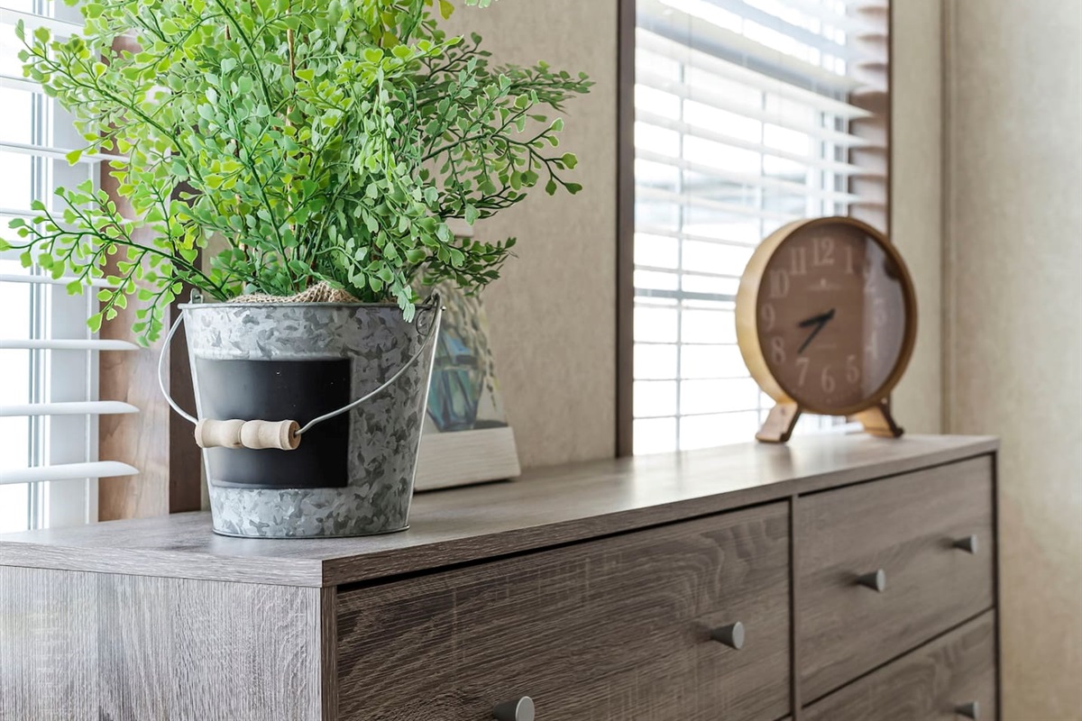 Modern dresser with decorative accents and natural light—perfect for storage during extended stays.