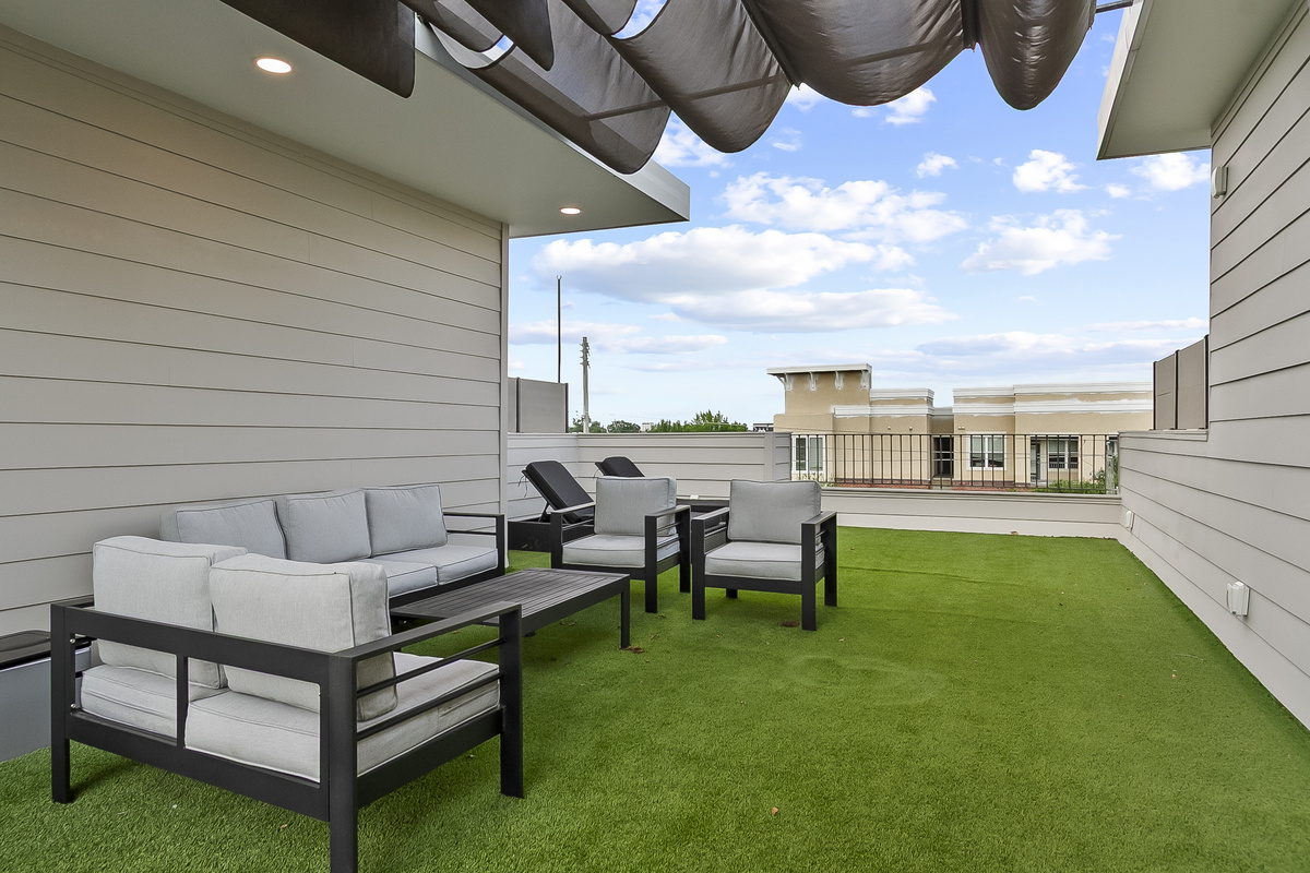 Rooftop Patio with seating, Large TV, gas grill and cornhole.