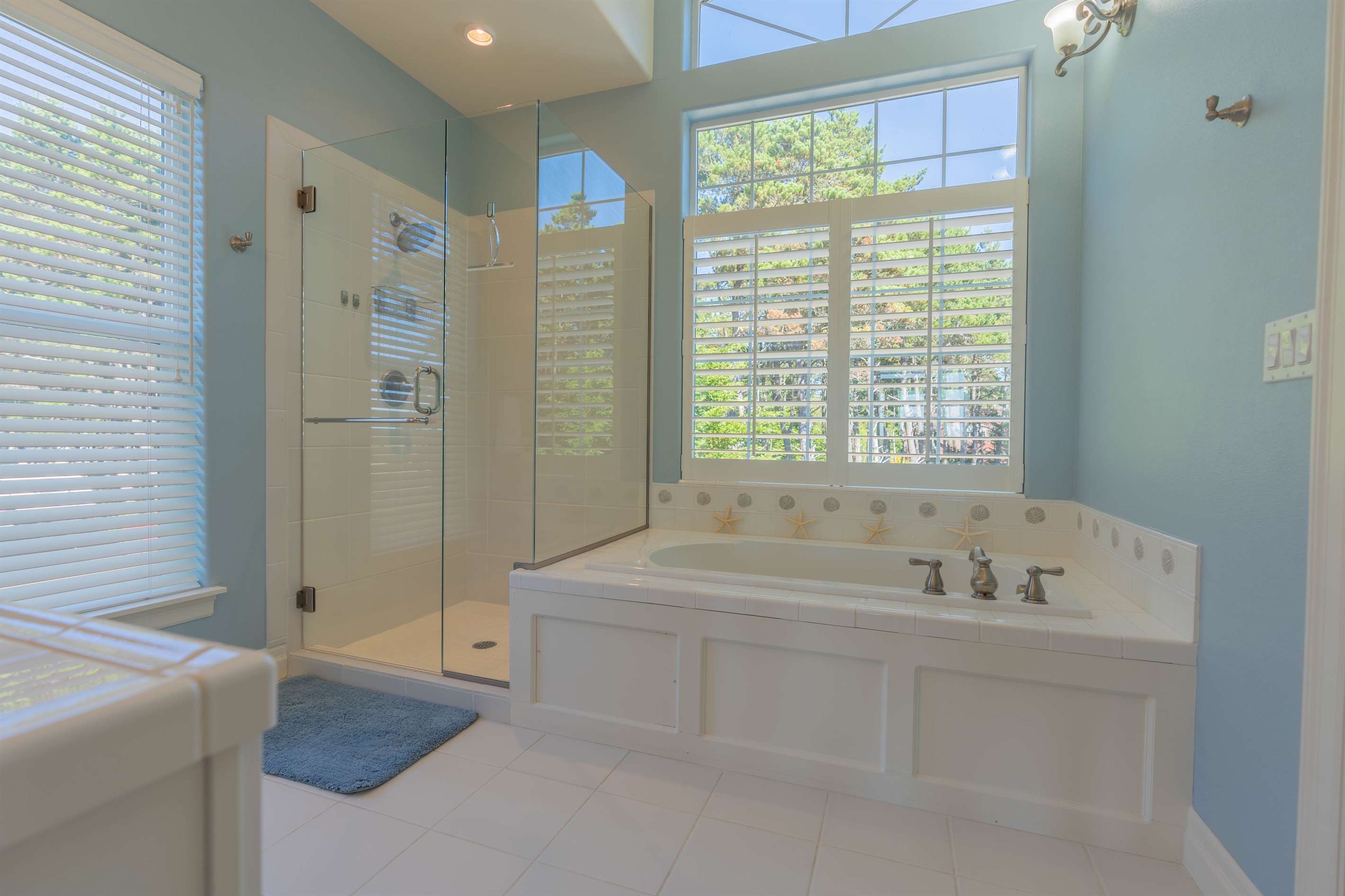 Sunny & bright 5 piece primary bath with jetted soaking tub and walk in shower.