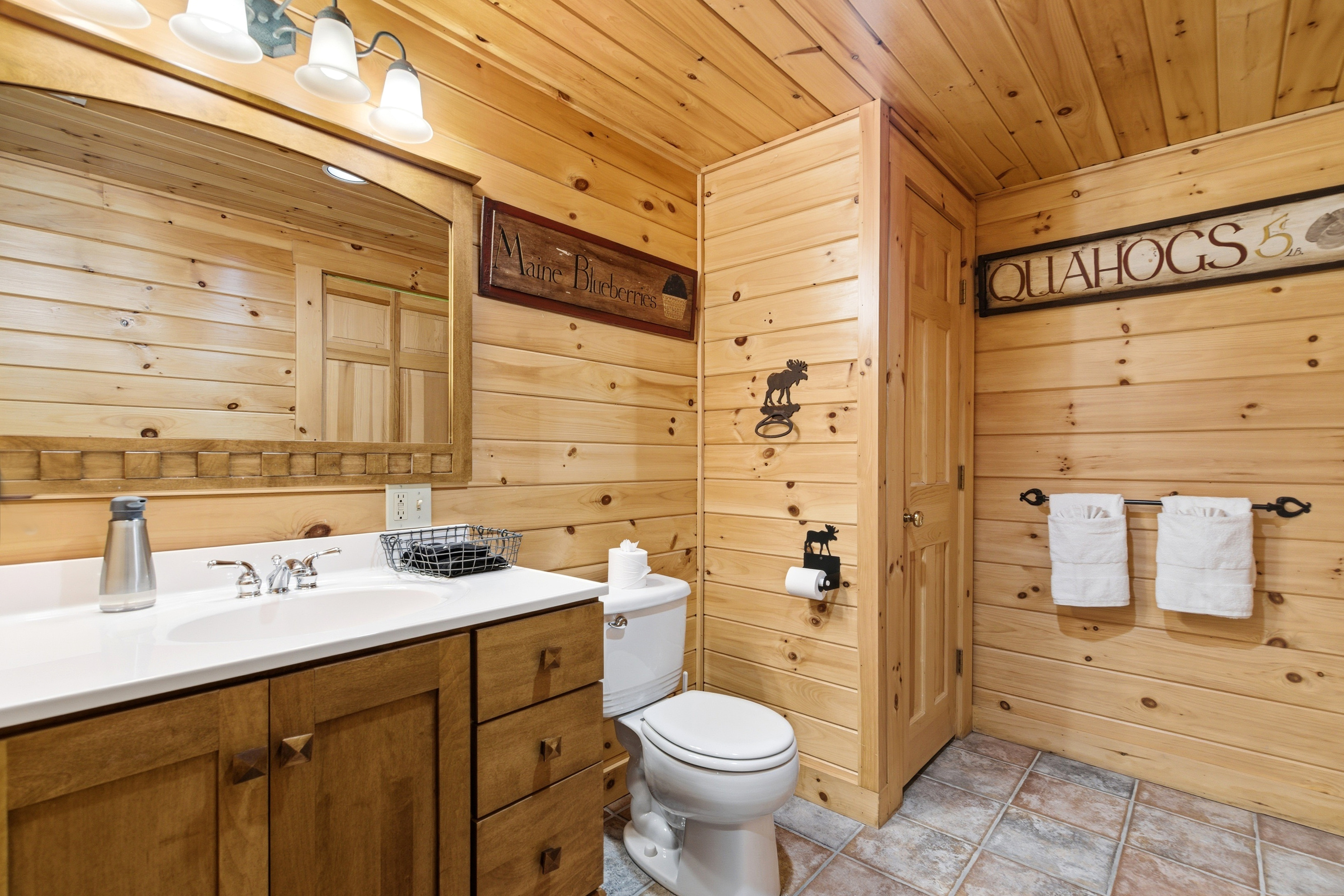 Bright and functional bathroom with ample counter space and rustic cabin finishes.