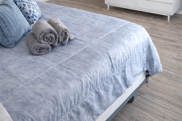 “Bright and airy attic bedroom featuring a plush queen bed, soft linens, and a Smart TV for relaxing nights in. The neutral tones and sloped ceilings create a cozy yet spacious retreat.”