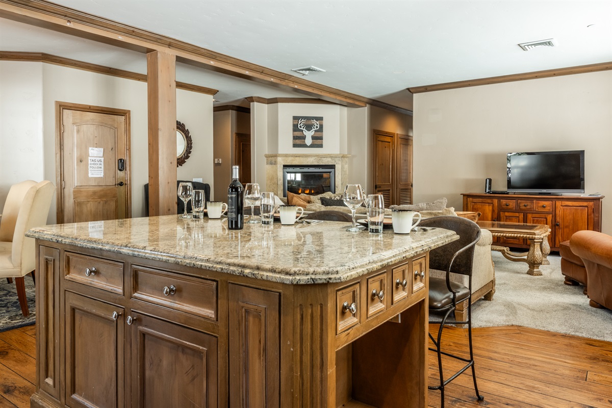 The open kitchen connects directly to the living area, with the breakfast bar serving as the natural hub for coffee, meals, and conversation.