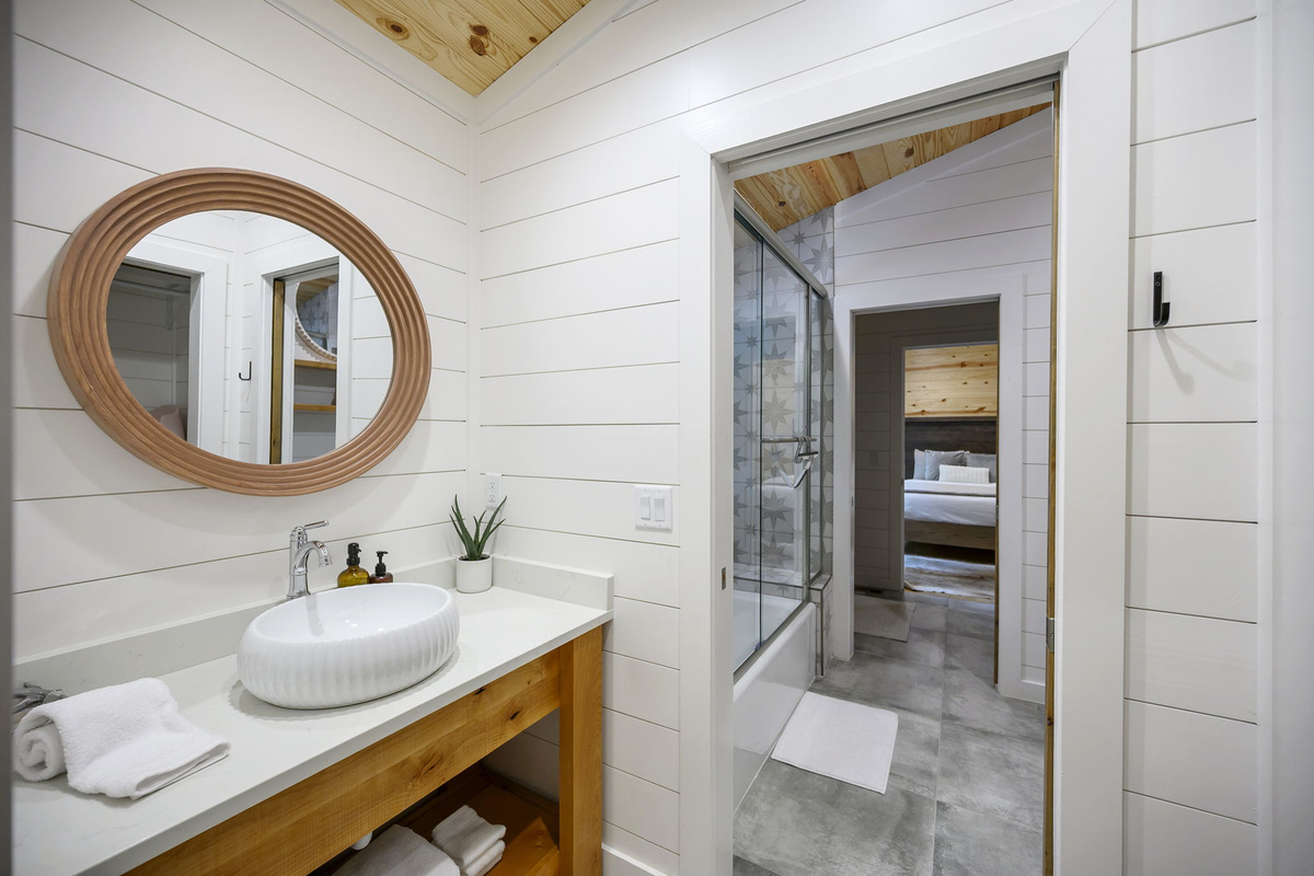 The shared full bathroom offers a cozy, spa-like feel with luxury finishes, warm design details, and everything guests need to feel comfortable and refreshed.