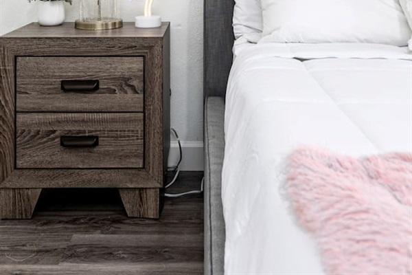 Add a little personality to your stay with a chic wood nightstand, a modern lamp, and a fun neon flamingo touch.

