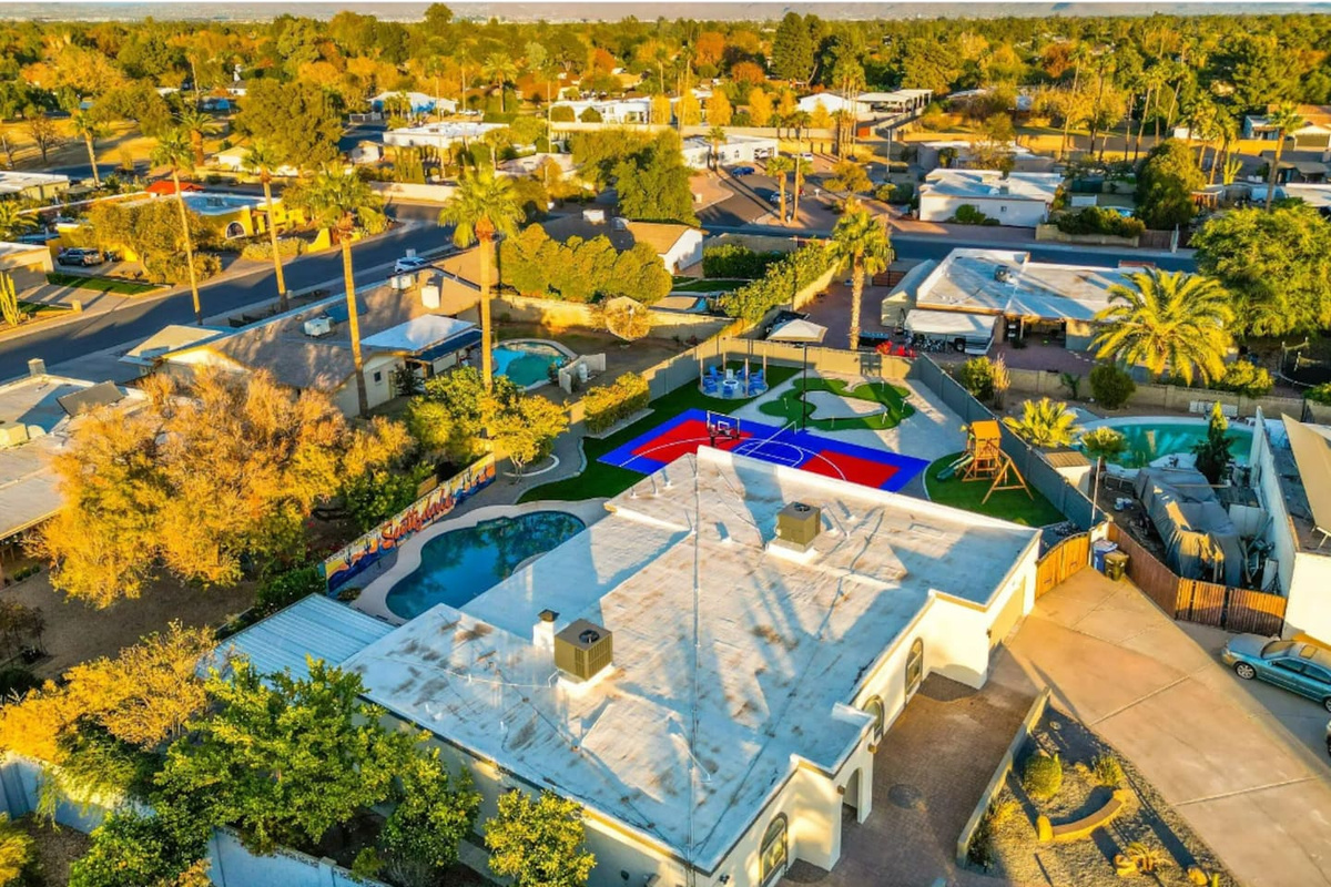 Pool, court, and putting green all visible in one frame — the kind of layout that lets everyone do their own thing at once.
