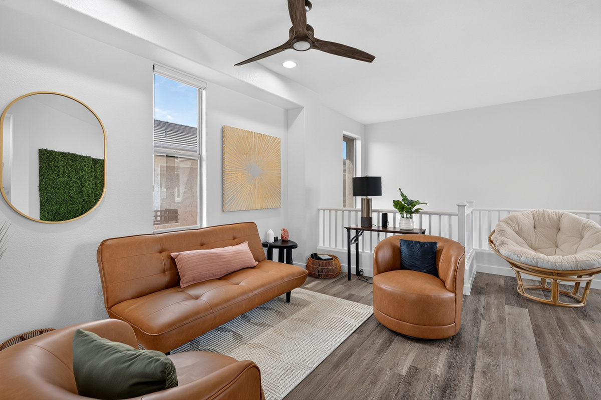 Open sitting area with accent chairs, sofa seating, natural light, and easy flow to the dining and living spaces.