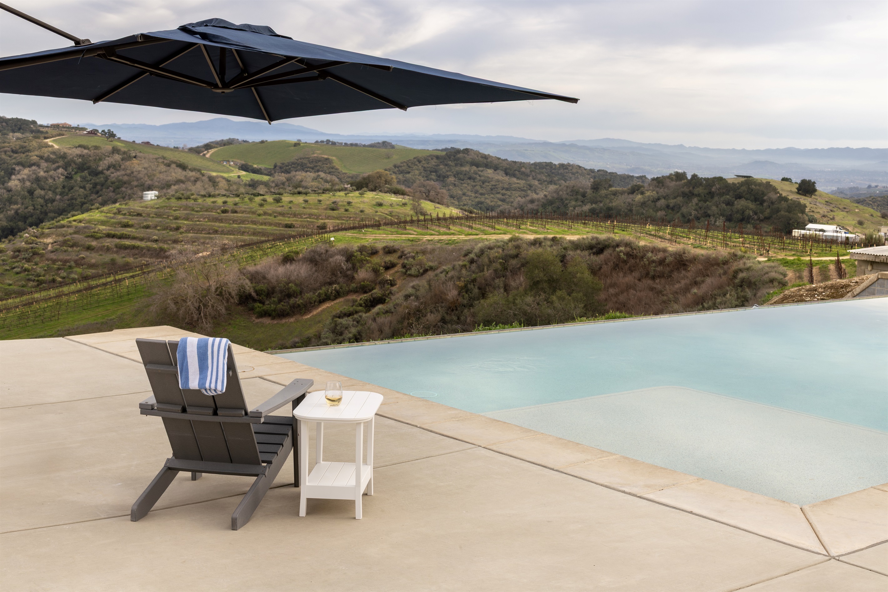 Your spot is waiting. One chair, one glass of wine, an infinity edge, and rolling vineyard hills as far as the eye can see.