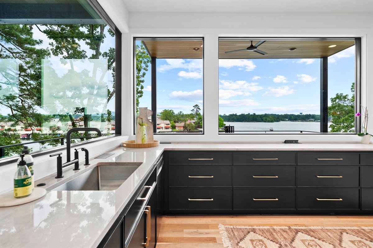 This kitchen’s open layout and stylish decor make it the heart of the home. The combination of dark cabinetry and light wood floors creates a welcoming atmosphere.