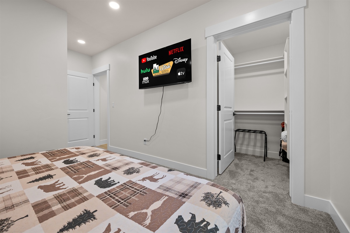 The primary bedroom features Smart TV, walk-in closet, and cozy bedding.