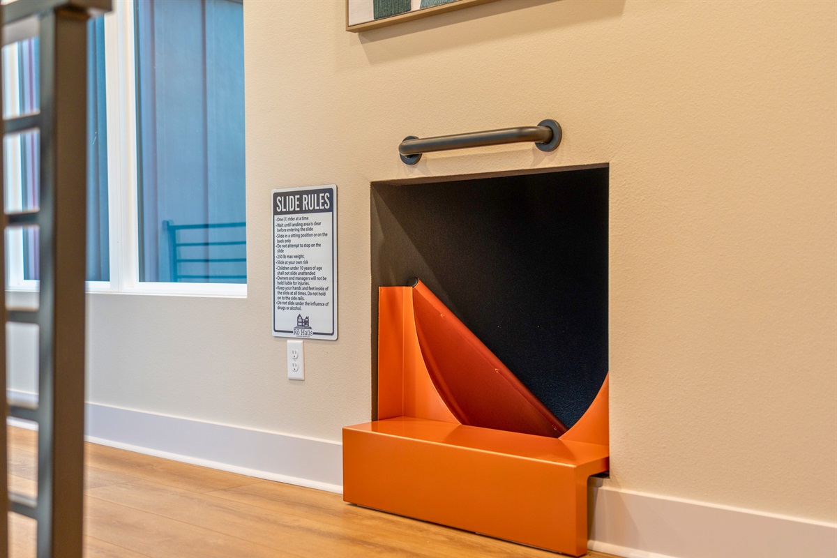 The slide's bold color contrasts beautifully with the room's sleek design, creating a visually appealing centerpiece.