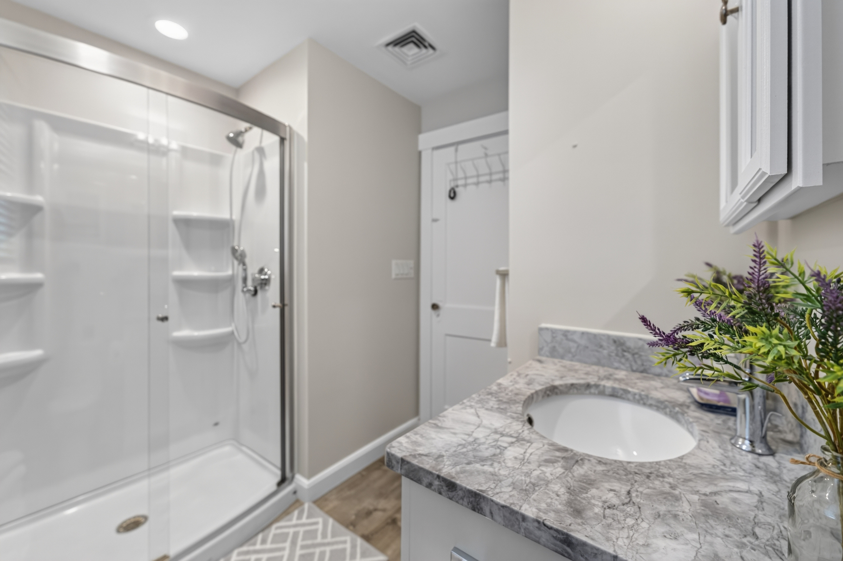 Full bathroom featuring a spacious vanity and walk-in shower for added comfort