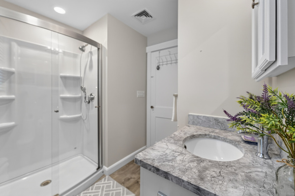 Full bathroom featuring a spacious vanity and walk-in shower for added comfort