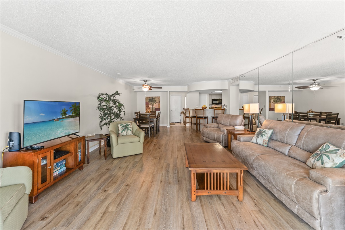 Spacious Living room with seating for everyone, large TV and balcony access