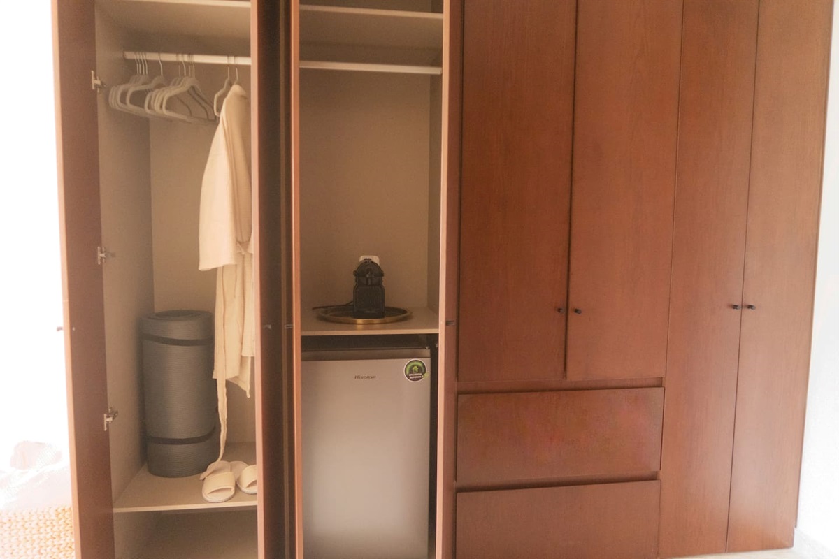 Bedroom #1 closet space comes with yoga mat, robes, a nespresso machine and mini fridge.