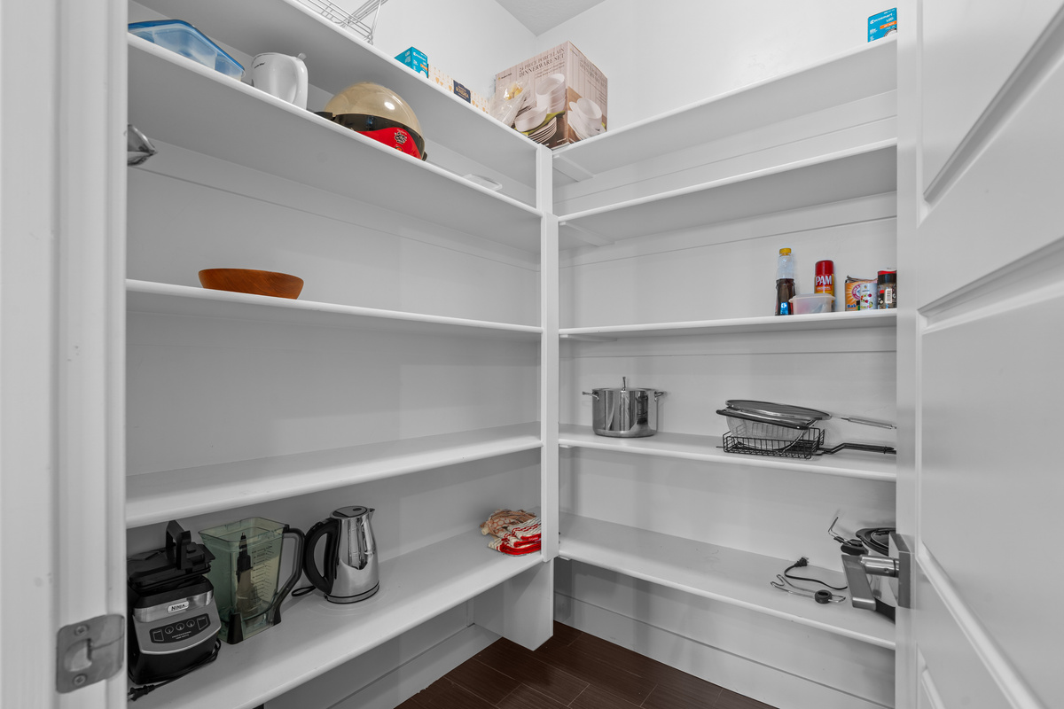 A spacious walk-in pantry keeps groceries and kitchen essentials organized.