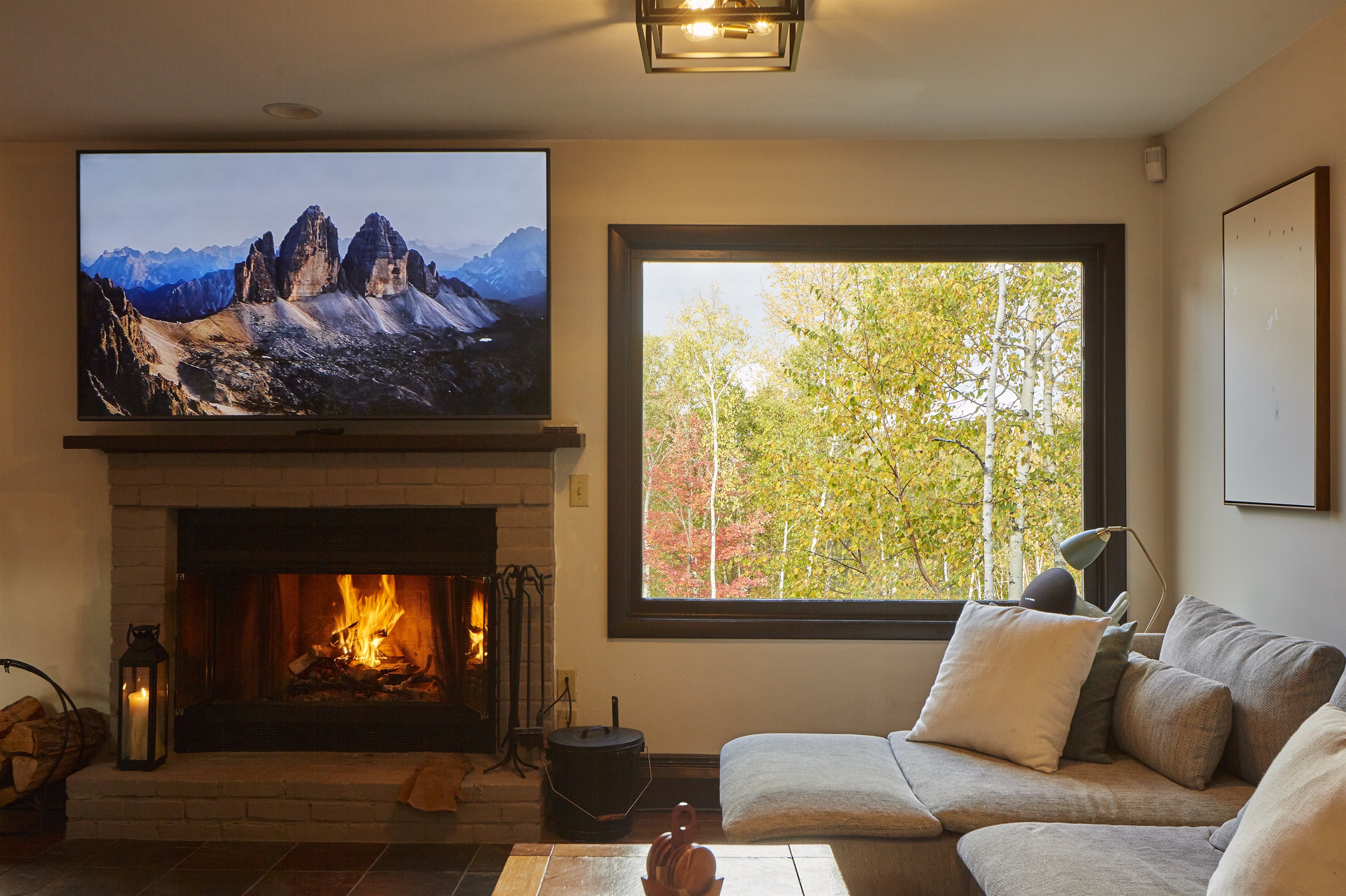 Experience warmth and comfort in the open-concept living room featuring a wood-burning fireplace and a 75” TV, perfect for family movie nights.