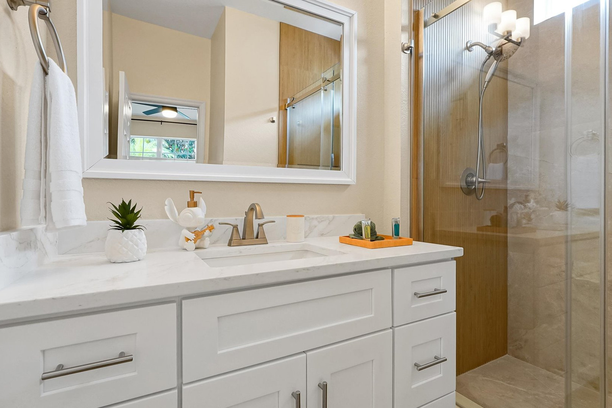 Stitch Queen Retreat Ensuite: Renovated private ensuite with a bright vanity and custom-tiled walk-in shower.