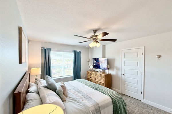 The spacious primary king bedroom featuring a 50" 4K HDR Smart TV and walk-in closet