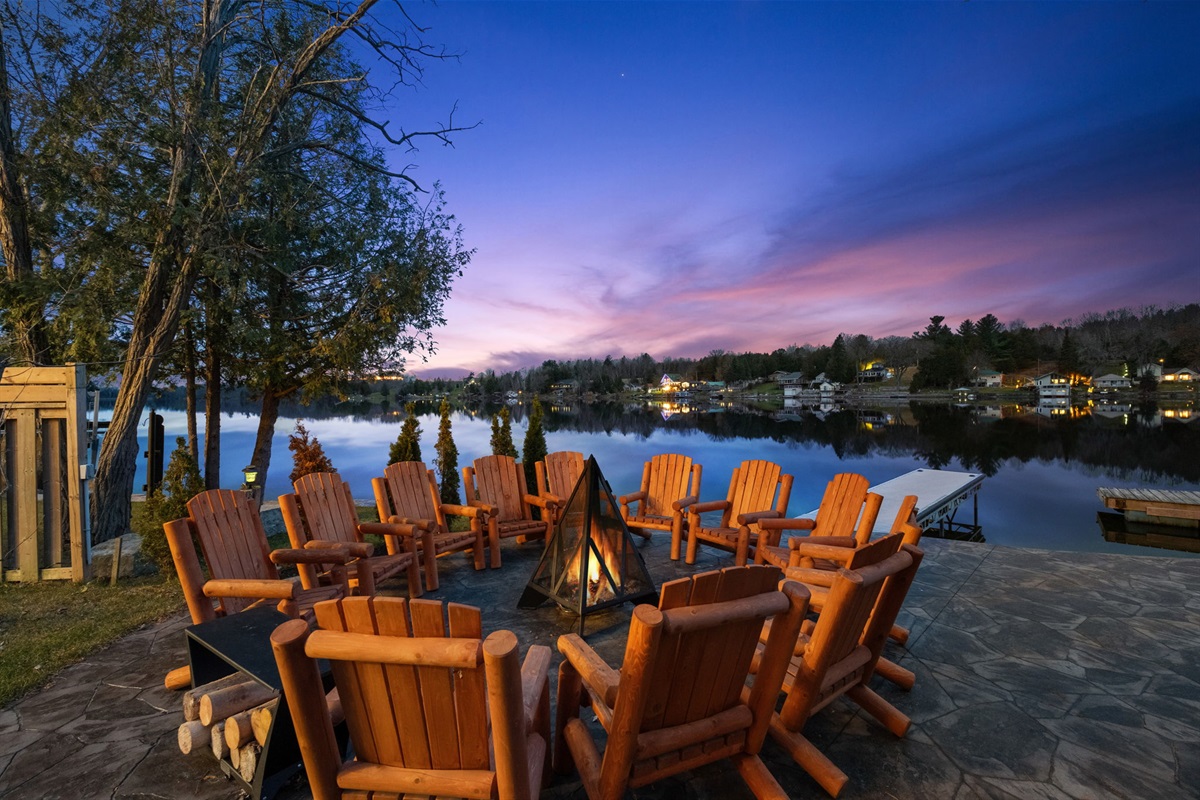 Lakeside firepit with rustic Adirondack seating for the whole group — unforgettable sunsets over the water.