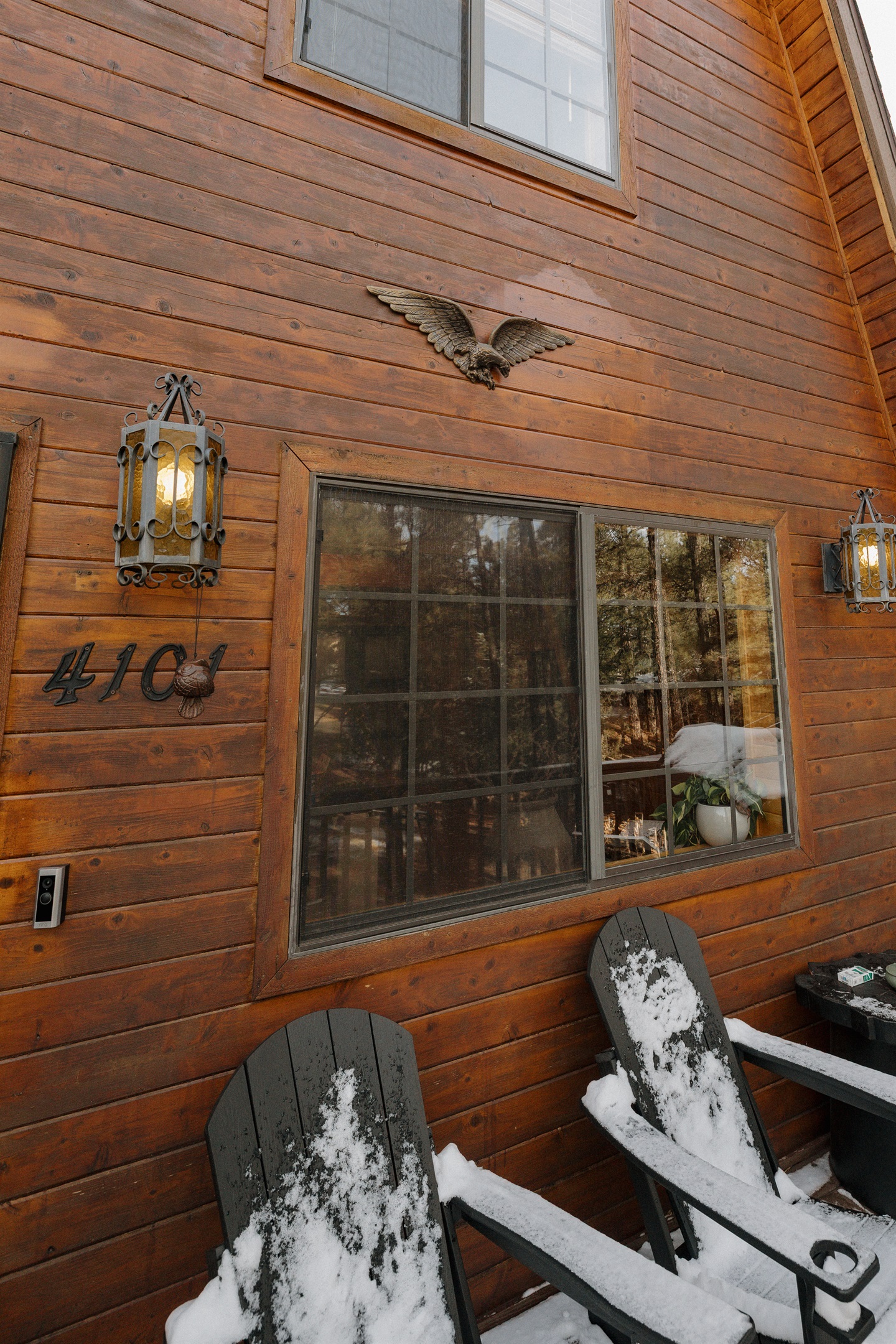 Charming A-frame cabin exterior with rustic wood siding, cozy seating, and forest surroundings—welcoming you to a peaceful White Mountains getaway just minutes from nature, trails, and fresh mountain air.