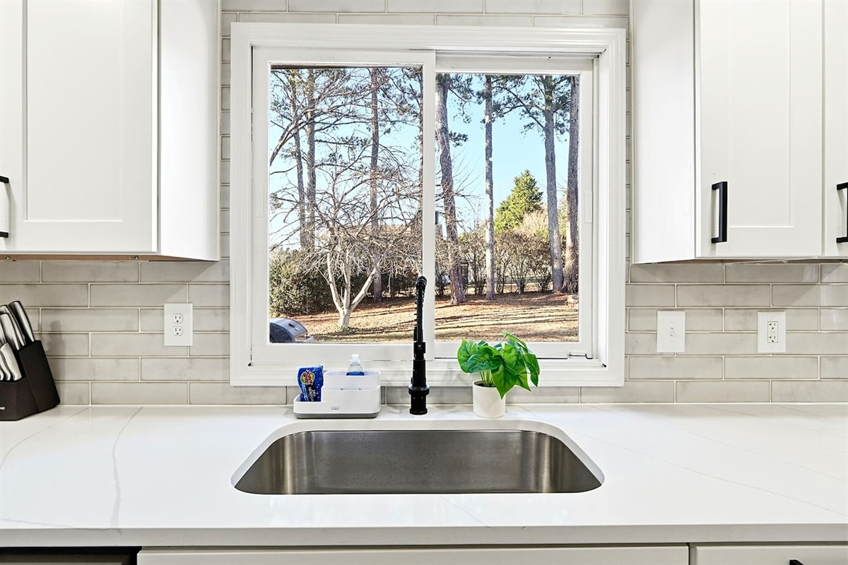 Bright white kitchen with a sleek, extended layout and ample counter space. The long layout offers plenty of countertop space, perfect for cooking, prepping, and everyday meals. Fully stocked with everything you need for a comfortable stay!
