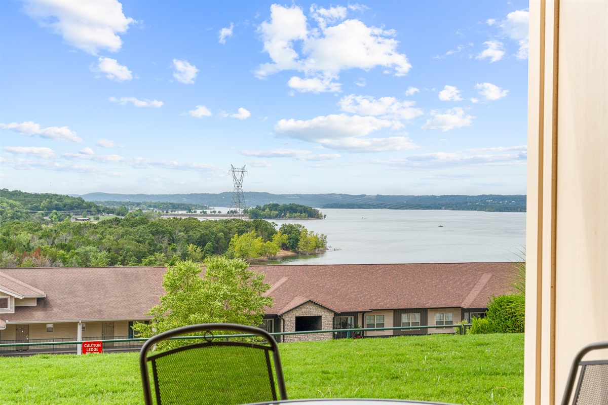 The patio opens to a broad lake panorama and a peaceful hillside setting.