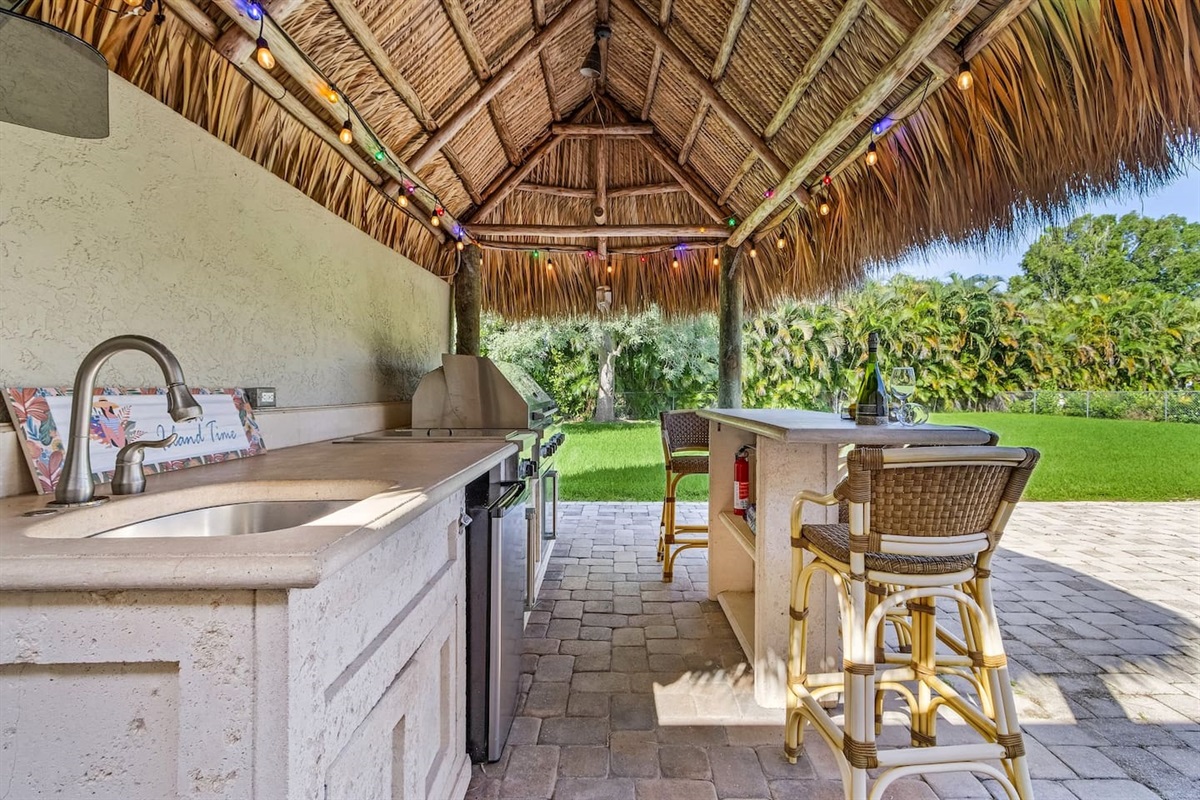 Experience the ultimate outdoor entertainment at the tiki bar, featuring a big BBQ grill, sink, and TV for the perfect blend of cooking and relaxation!