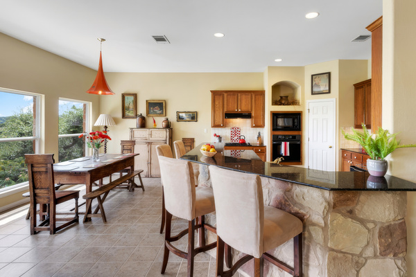 Kitchen bar seating with granite counters, open to the dining area