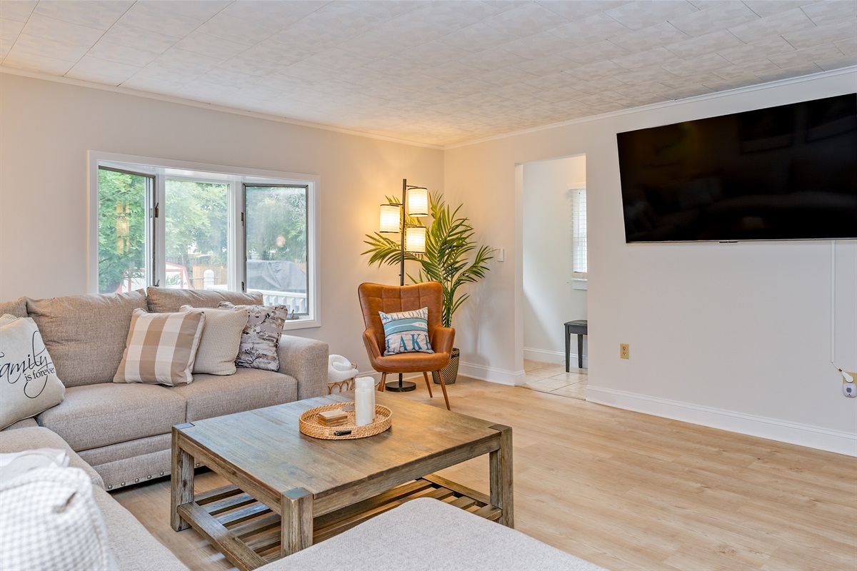 Catch the game or a movie night on the large smart TV  or play a game of ring toss in this inviting living room designed for comfort and connection.