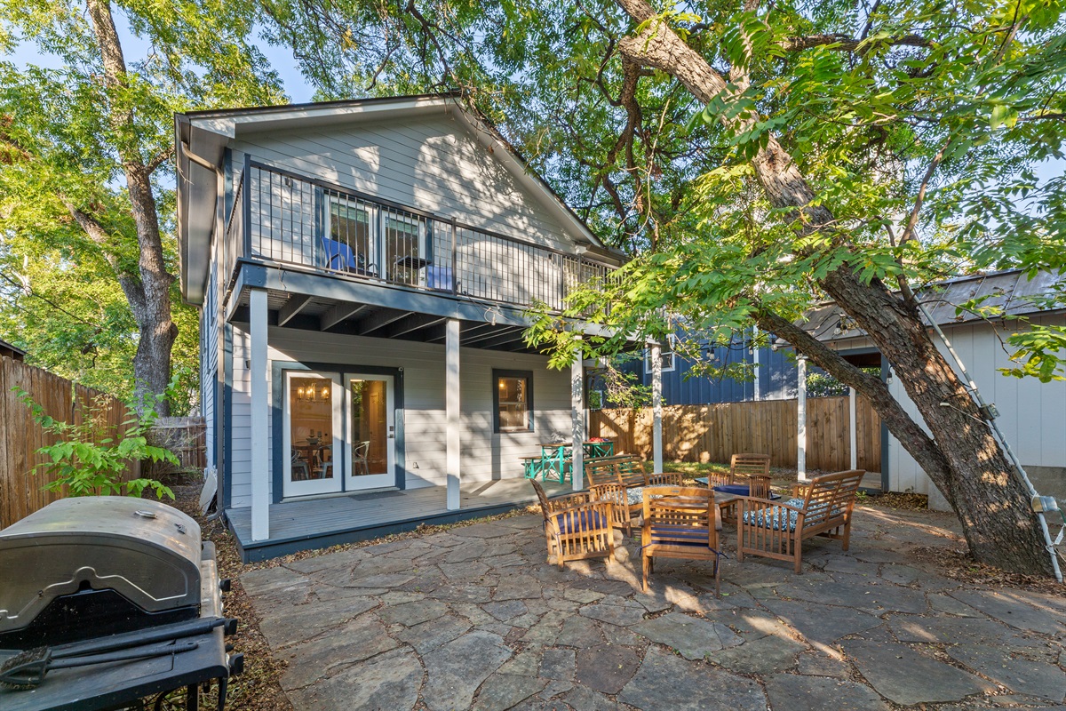 Propane grill and plenty of seating with beautiful trees