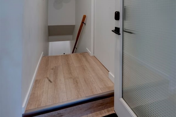 Stairway leading down to the lower-level suites. Shoe storage is just inside the entry.