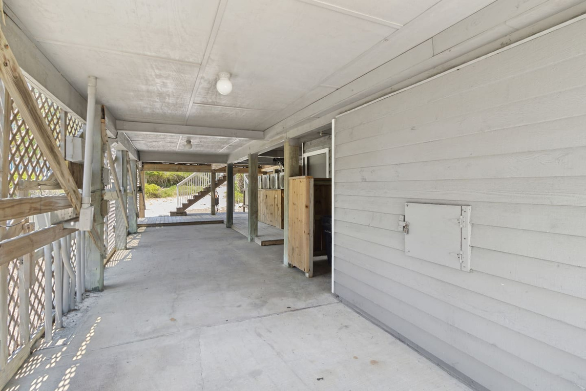 Two-car covered carport plus a water hose for sandy feet &mdash; the little details that make a beach trip easier.