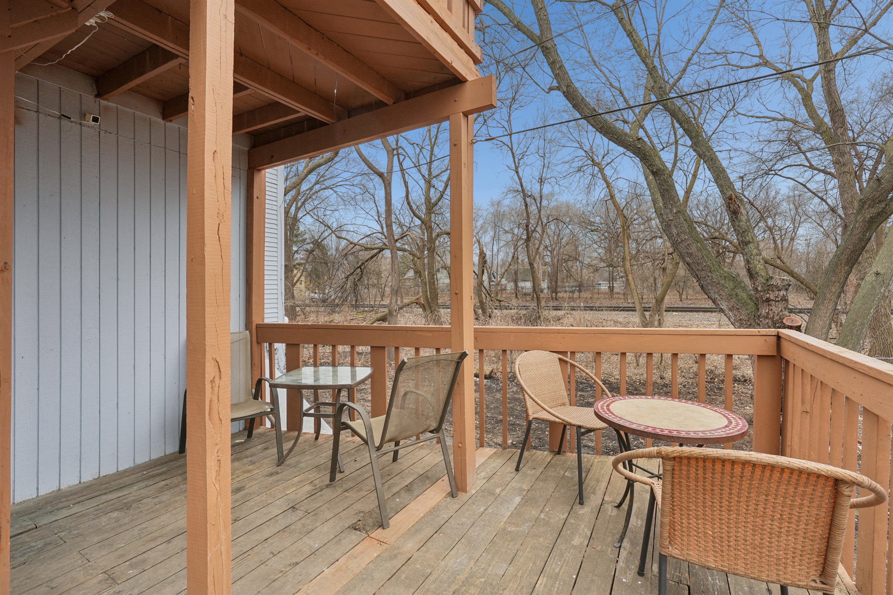 The spacious rear deck overlooks the woods, tracks and backyard.
