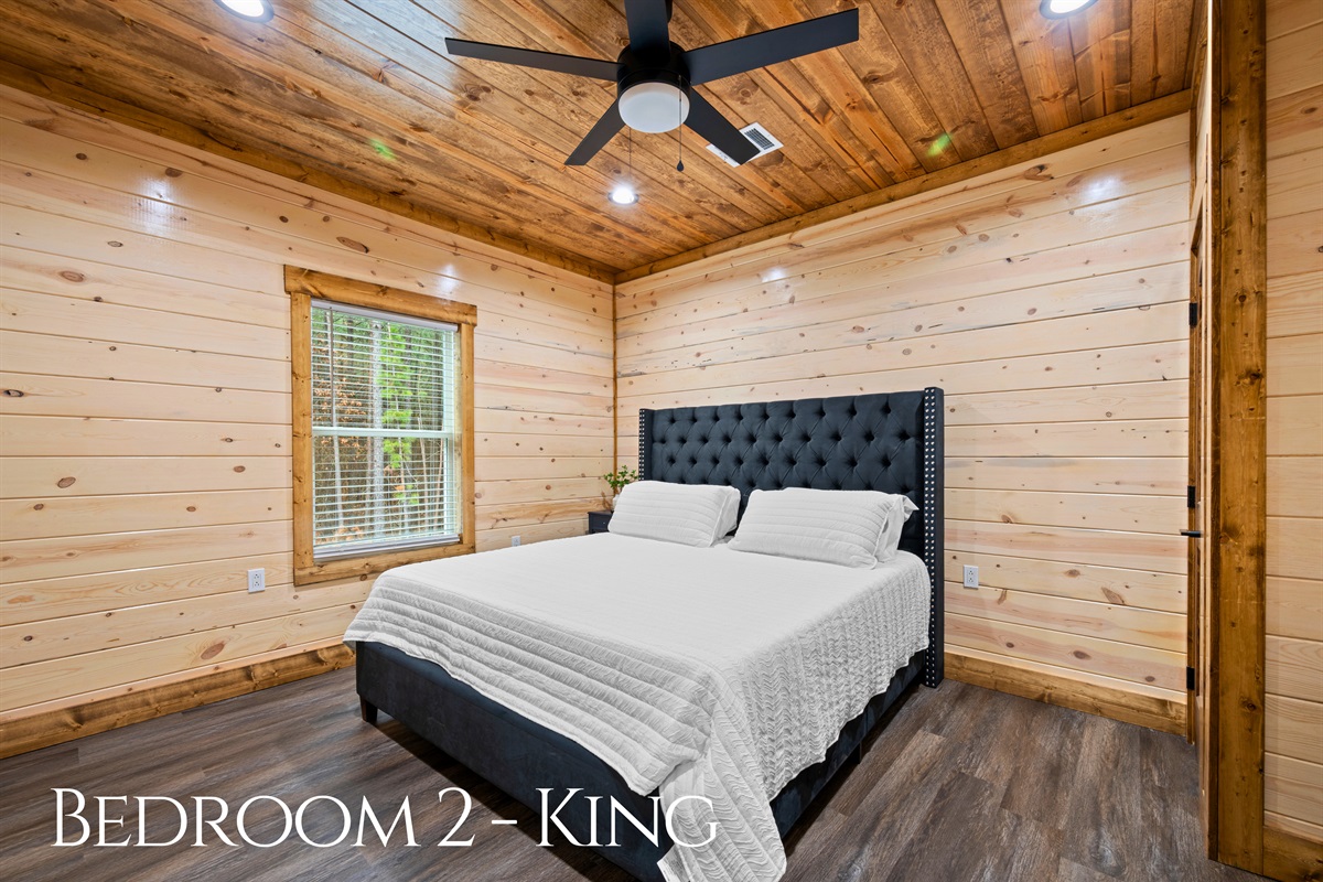 Another comfortable king bedroom provides a quiet retreat with a soft bed, warm lighting, and just the right amount of space to unwind and relax.