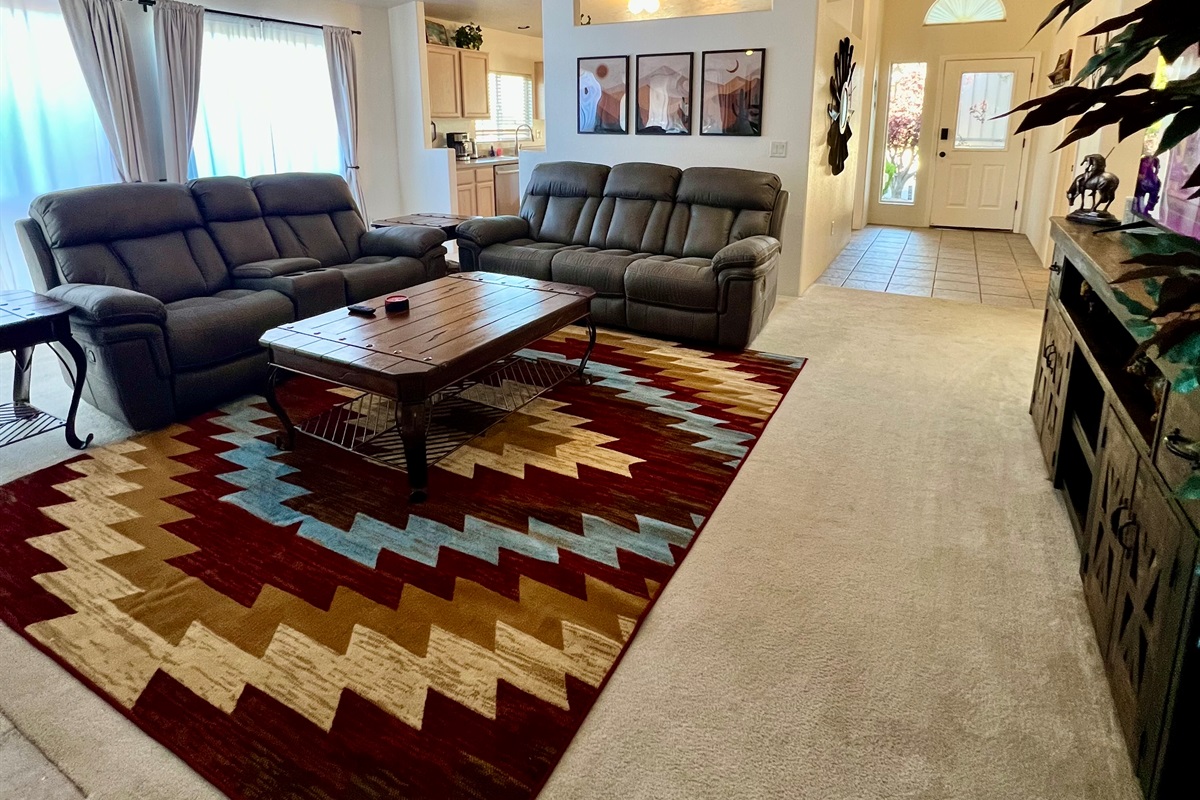 The home's open floor plan seamlessly connects the kitchen, living room, and dining room, creating a spacious and airy feel perfect for entertaining and spending time together.