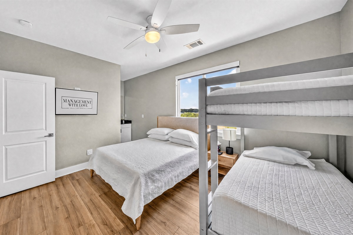 - Guest room with queen bed and bunks offers comfort for families - Soft carpet and bright natural light create a relaxing, restful stay - Functional layout supports groups enjoying a peaceful lake getaway