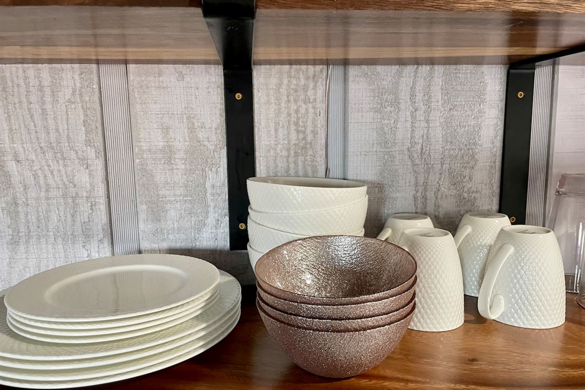 Dishes, basic cookware, and silverware are available in the kitchen/cooking space.
