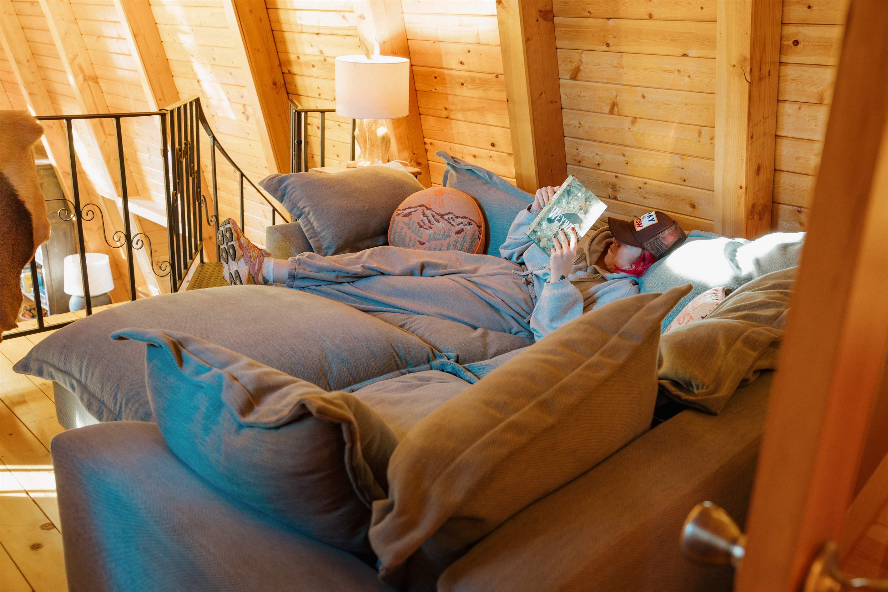 The loft reading nook at Poppywood Pines offers a cozy retreat flooded with natural light through dramatic A-frame windows. This pet-friendly Show Low cabin provides the perfect spot to relax with a book after exploring White Mountains hiking trails and fi