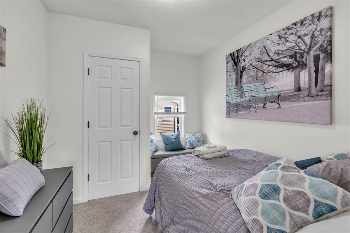 Relaxing bedroom with a scenic view through the window, bringing in natural light and a refreshing breeze.