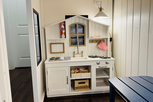**Kid-sized play kitchen with sink, stovetop and oven for little chefs.**