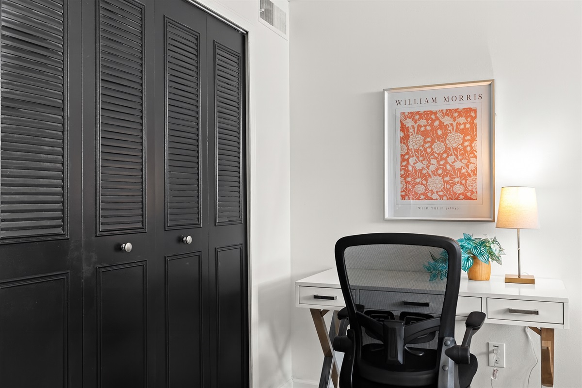 Stylish workspace nook with artistic touches and a nearby closet for added functionality.