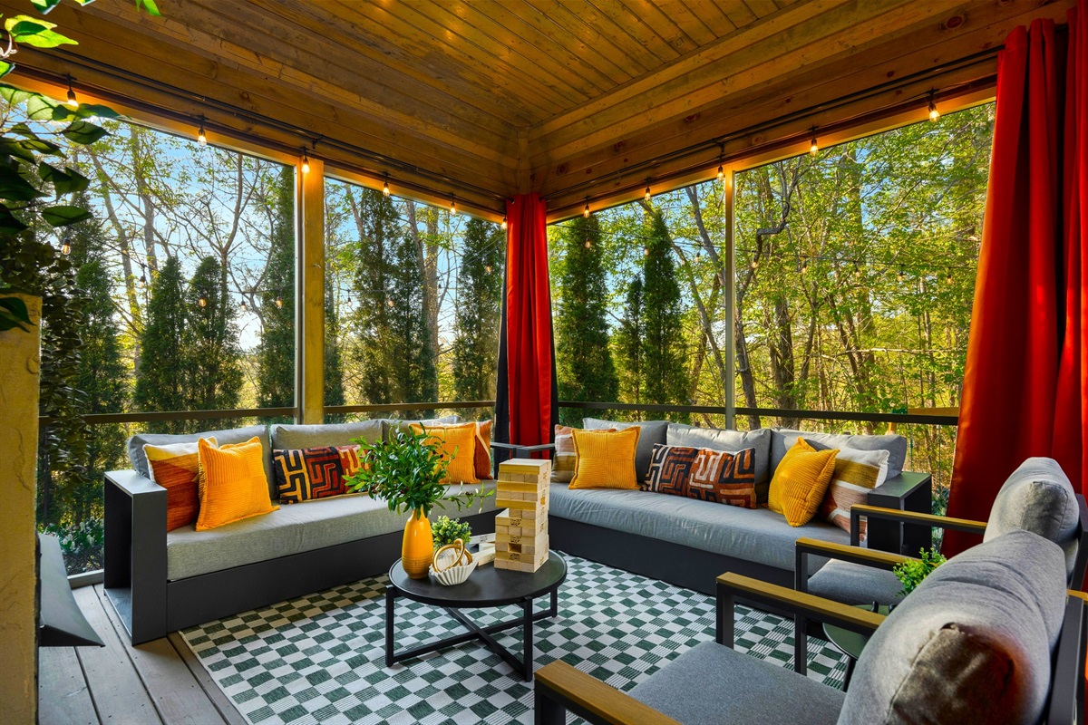 Screened-in porch with cozy seating - ideal for morning coffee in the fresh Asheville mountain air